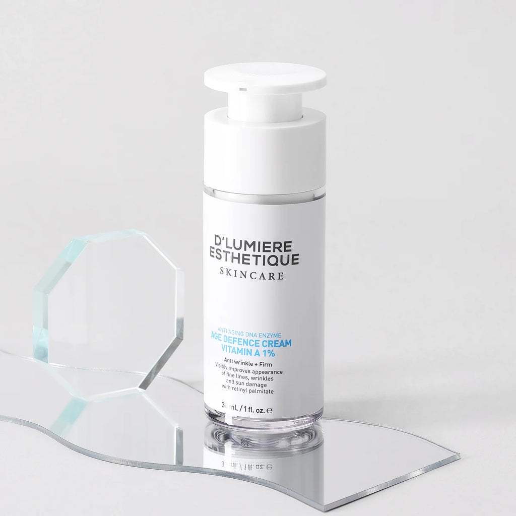 Skincare bottle labeled 'Age Defence Cream Vitamin A 1%' on a clear stand with a light gray background