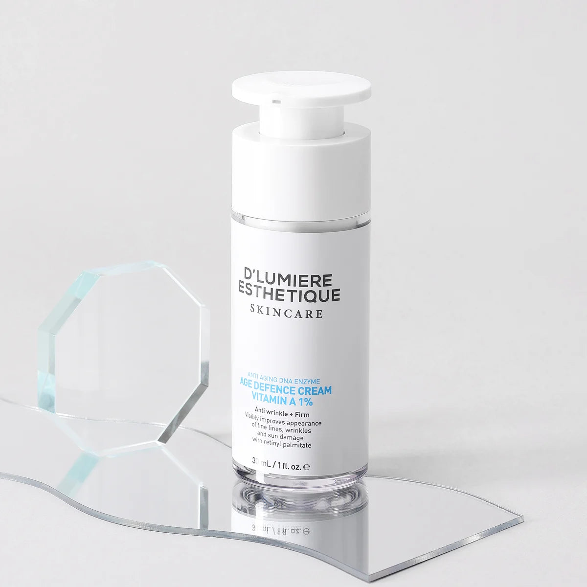 Skincare bottle labeled 'Age Defence Cream Vitamin A 1%' on a clear stand with a light gray background