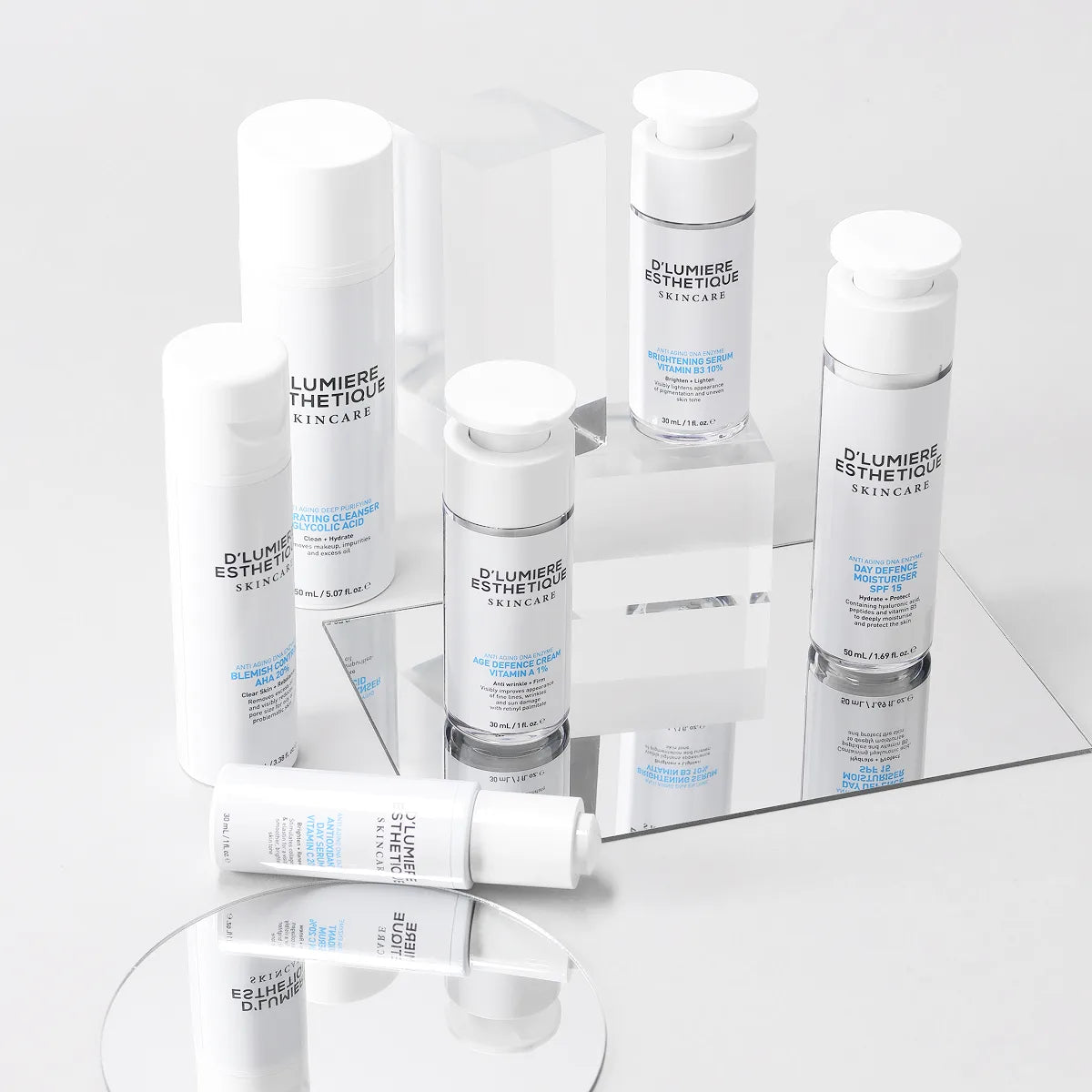 Collection of skincare products from D' Lumiere Esthetique on a reflective surface with a light gray background.