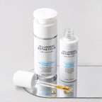 Two skincare bottles from D'lumiere Esthetique on a gray background